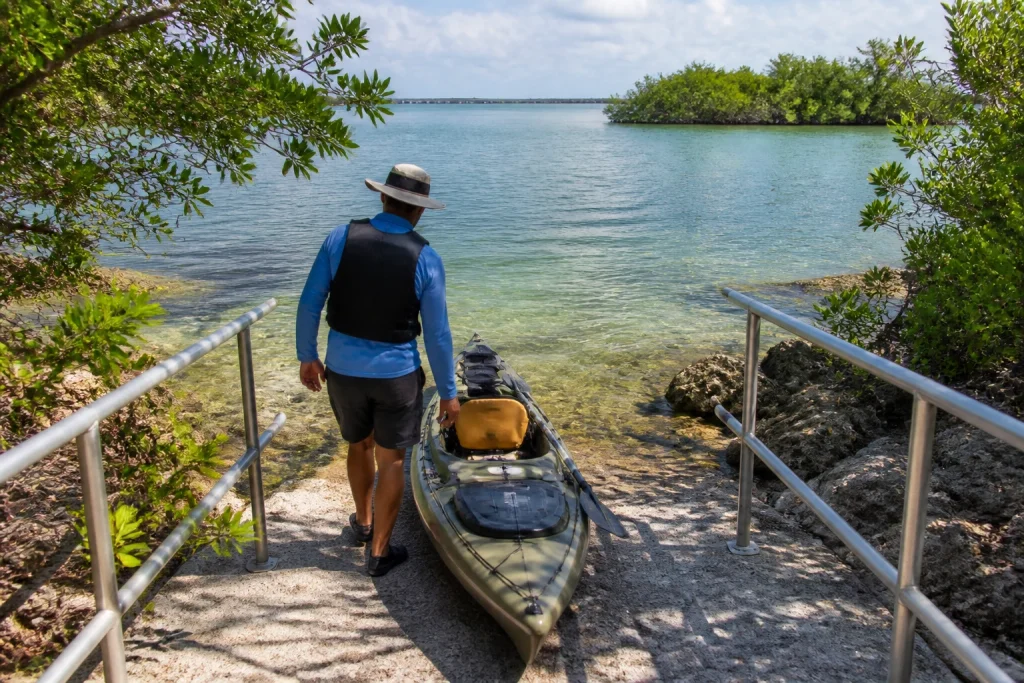 A paddler entering a kayak from a ramp with railings near Geiger Key.