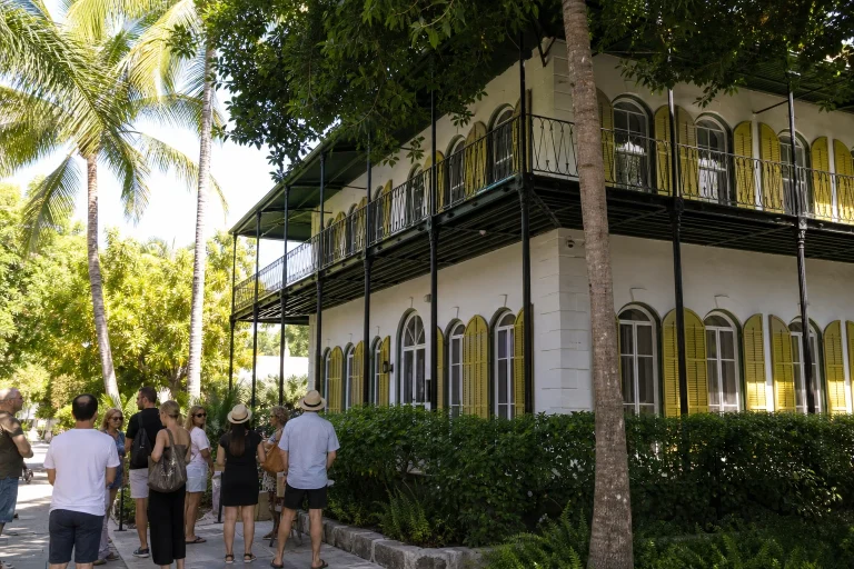 Visitors outside a historic tropical home in Key West before a walking tour