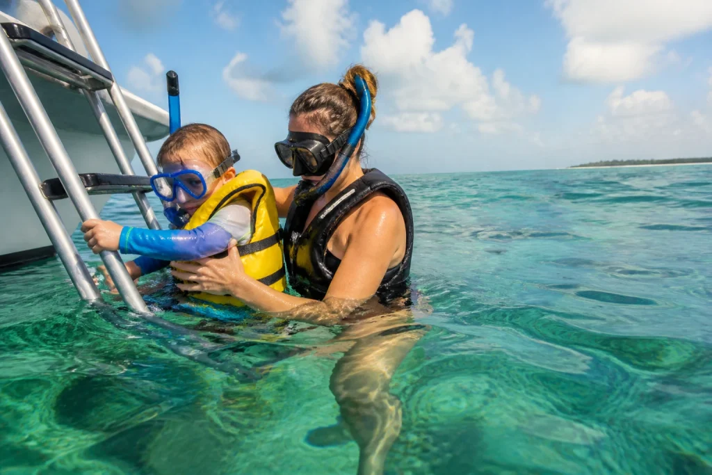 Parent and child using a boat ladder during a Key West snorkeling trip